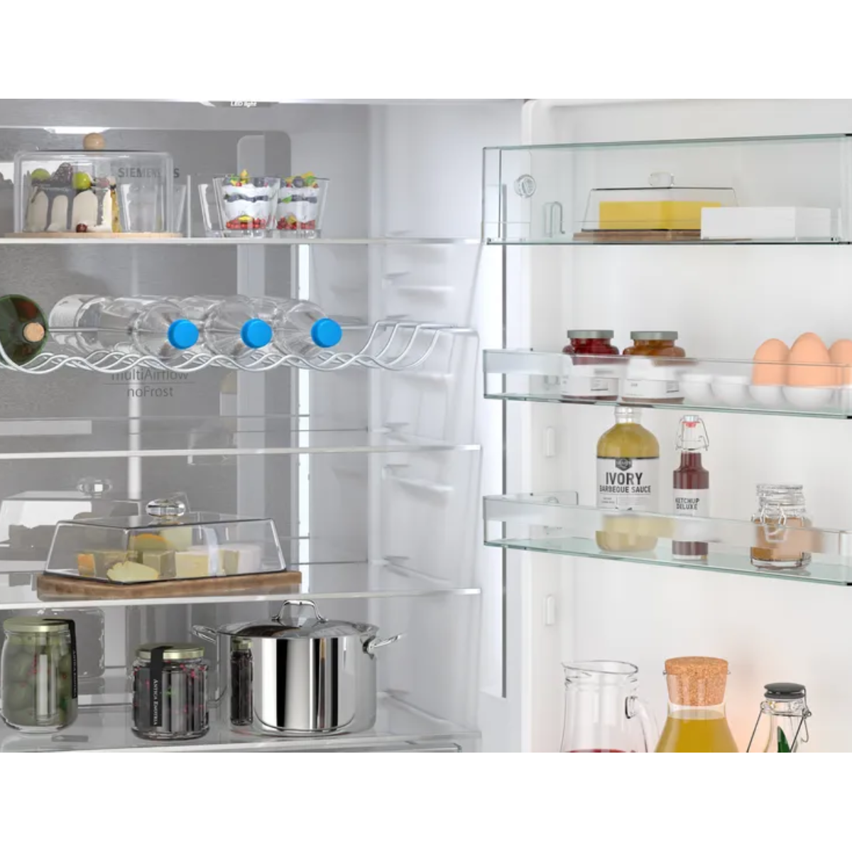 Gefüllter Kühlschrank mit Kuchen, Desserts, Flaschen, Käse, Töpfen und Eiern.