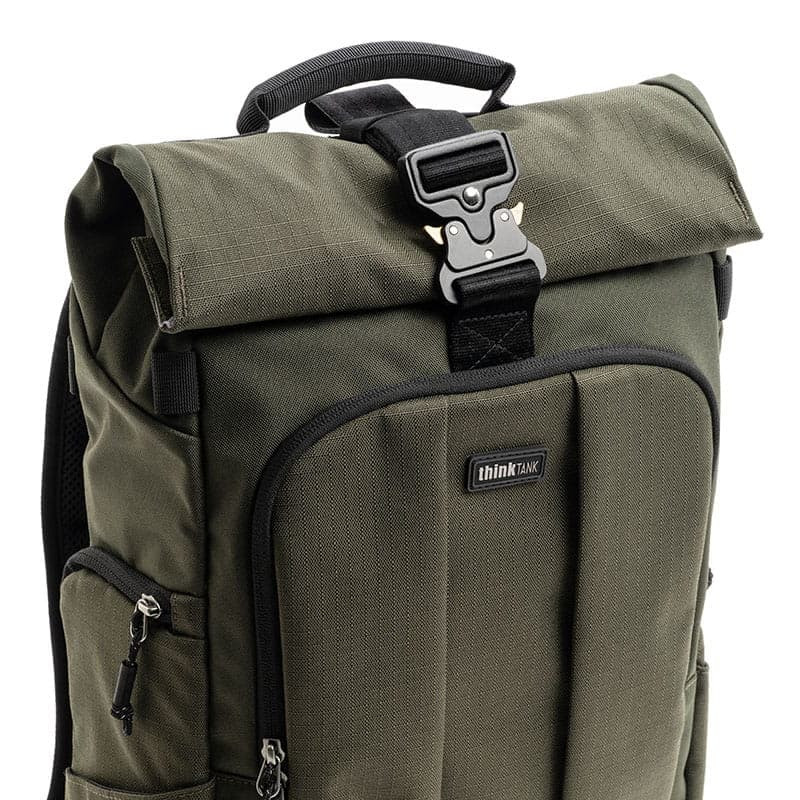 A green backpack with a roll-top closure and a black buckle.