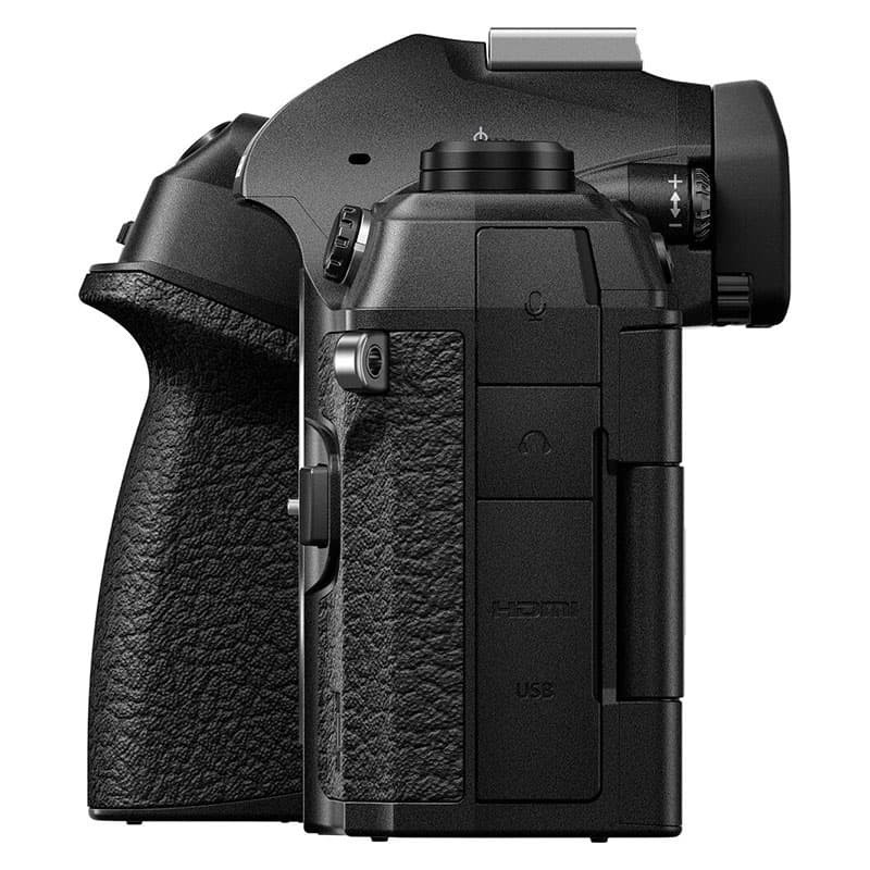 Zwarte digitale camera van de zijkant, met grip en poorten.