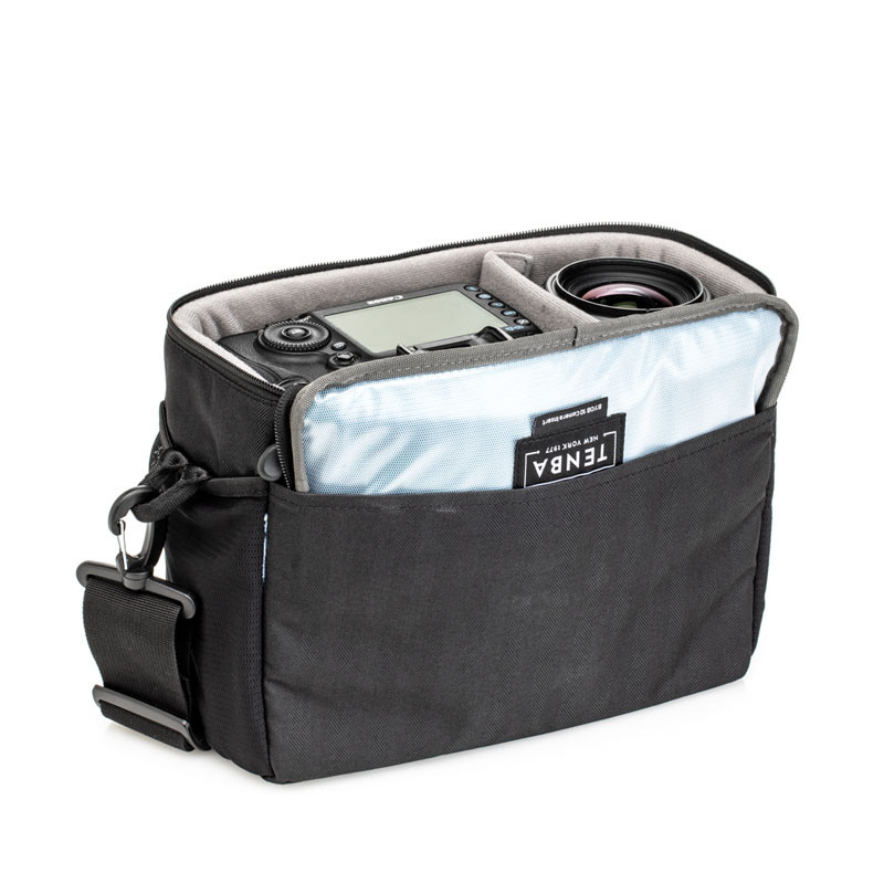 A black camera bag with a digital camera and lens inside, on a white background.