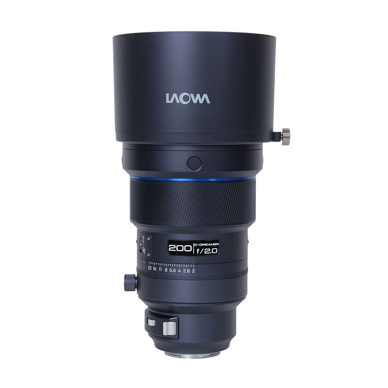 A black Laowa 200mm f/2.0 lens with a wide hood and focus ring.