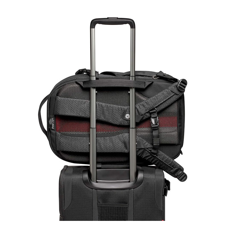 A black backpack with a silver telescopic handle sits atop a black suitcase.