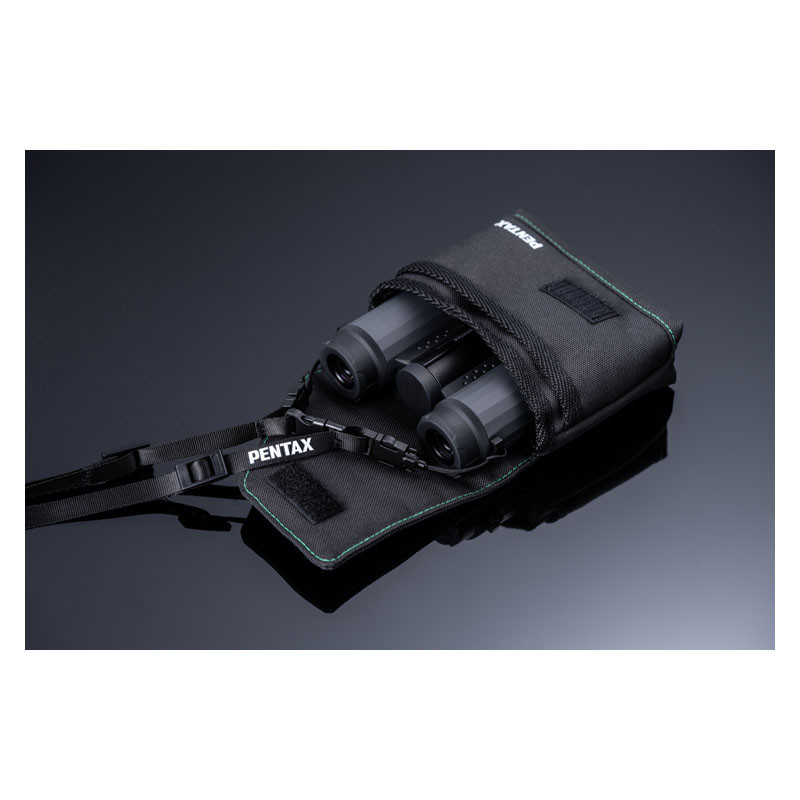 Eine schwarze Pentax-Fernglastasche mit Fernglas und Riemen darin.