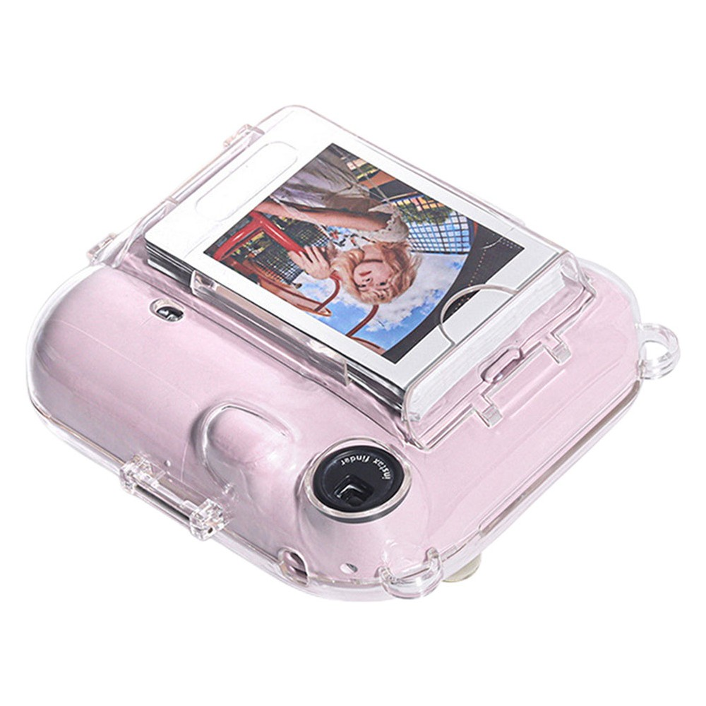 Şeffaf kılıflı pembe bir anlık kamera, üzerinde bir kadın fotoğrafı var.