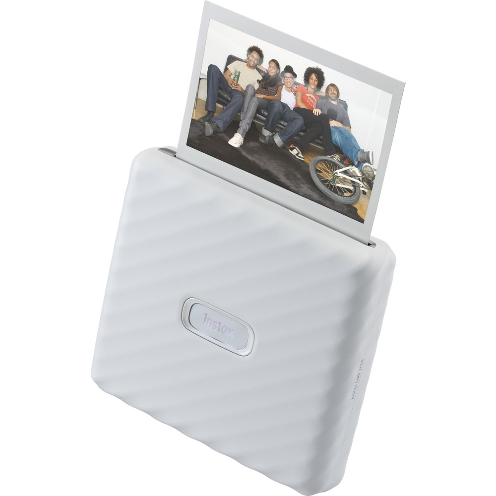 Beyaz bir Instax yazıcı, kanepede oturan bir grup arkadaşın fotoğrafını çıkarıyor.