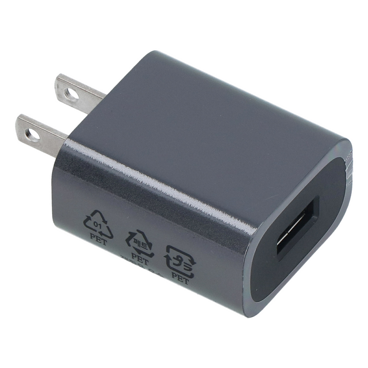 Ciemny adapter zasilający USB z dwoma płaskimi bolcami i portem USB.