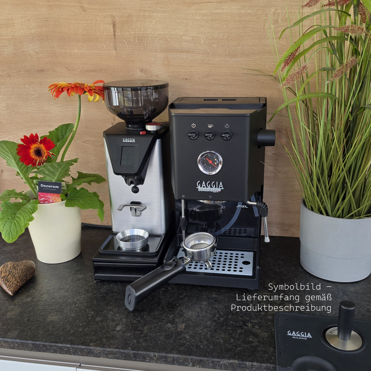 Kaffeemühle und Espressomaschine mit Blumen und Pflanze auf dunkler Arbeitsplatte.