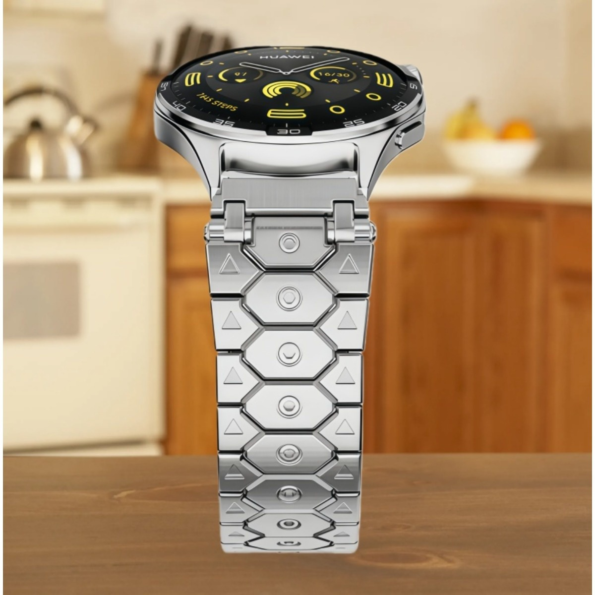 Uno smartwatch argentato con quadrante nero e accenti gialli riposa su un tavolo di legno.