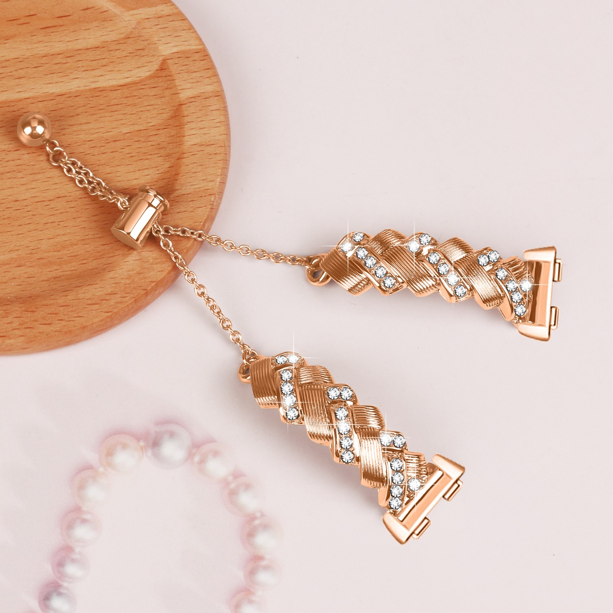 Zwei goldene Armbandteile mit Kristallen, verbunden durch eine Kette.