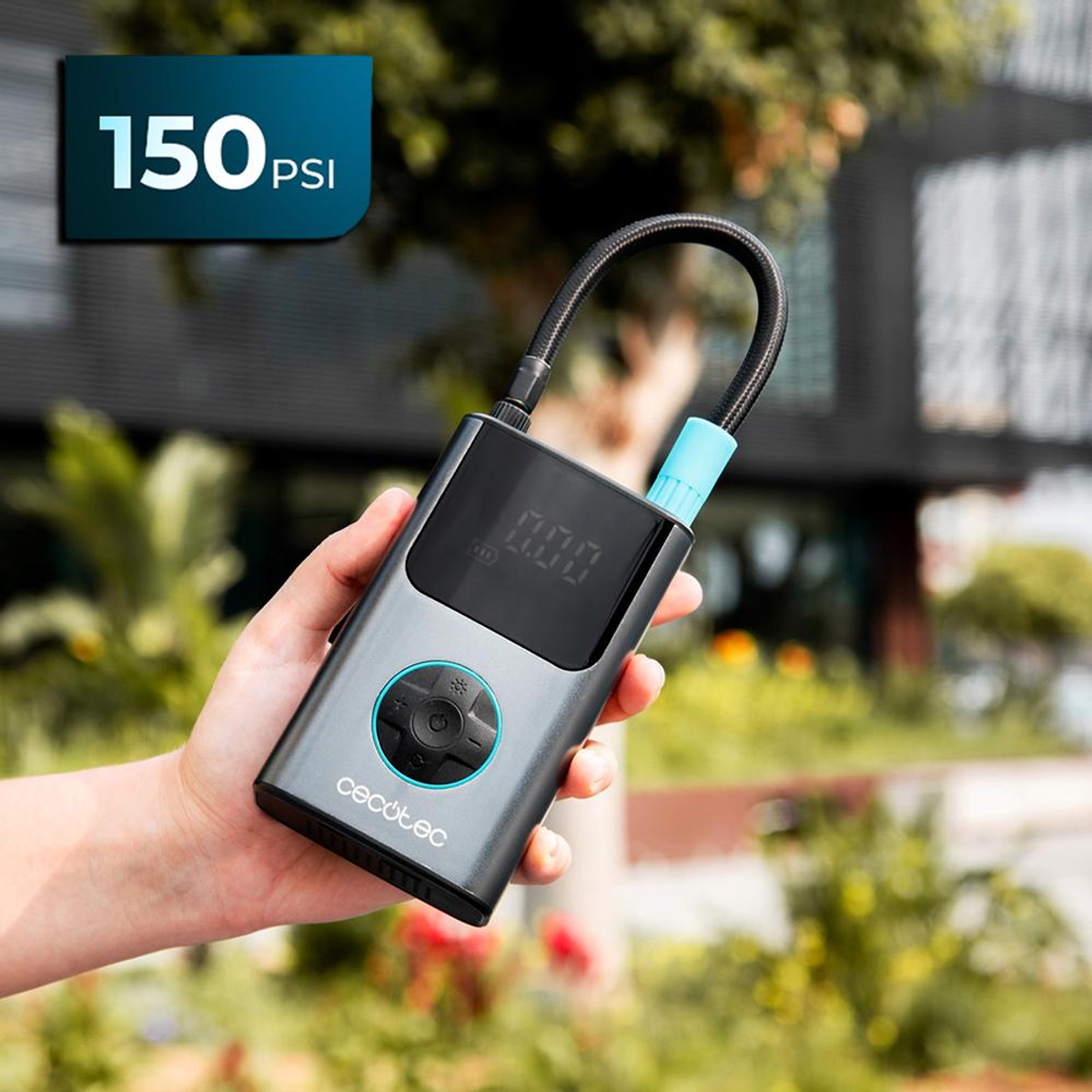 Una mano sostiene un compresor portátil con pantalla digital. 150 PSI.
