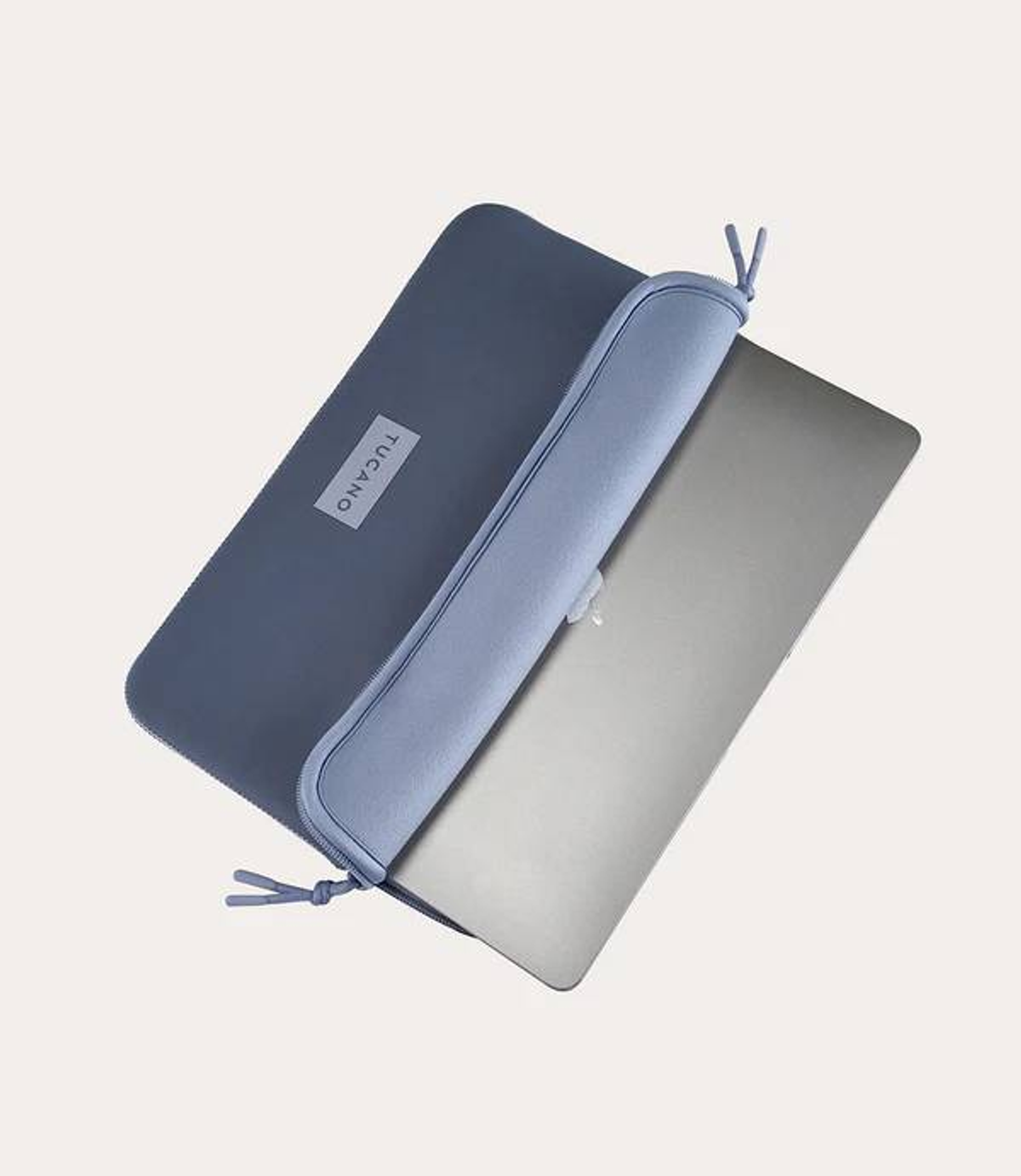 Graue Laptoptasche mit hellem Innenfutter, ein Silber-Laptop wird hineingeschoben.
