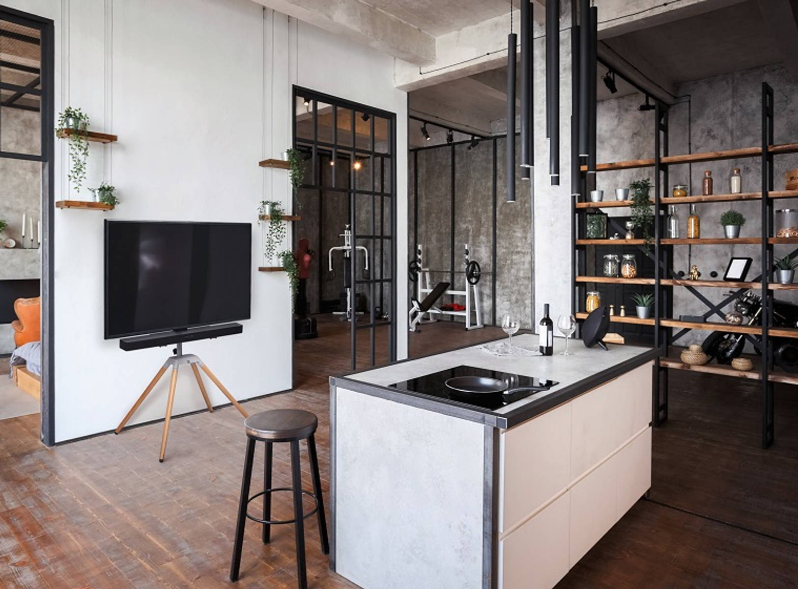 Loft-Interieur mit TV, Kücheninsel, Fitnessbereich und Regalen.
