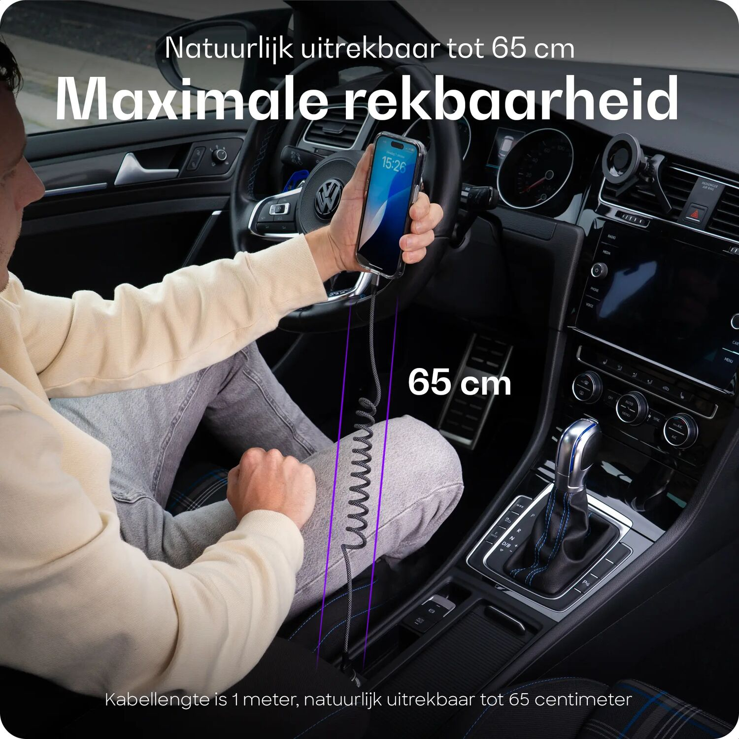 Man in auto houdt telefoon vast, toont oplaadkabel 65 cm uittrekbaar.