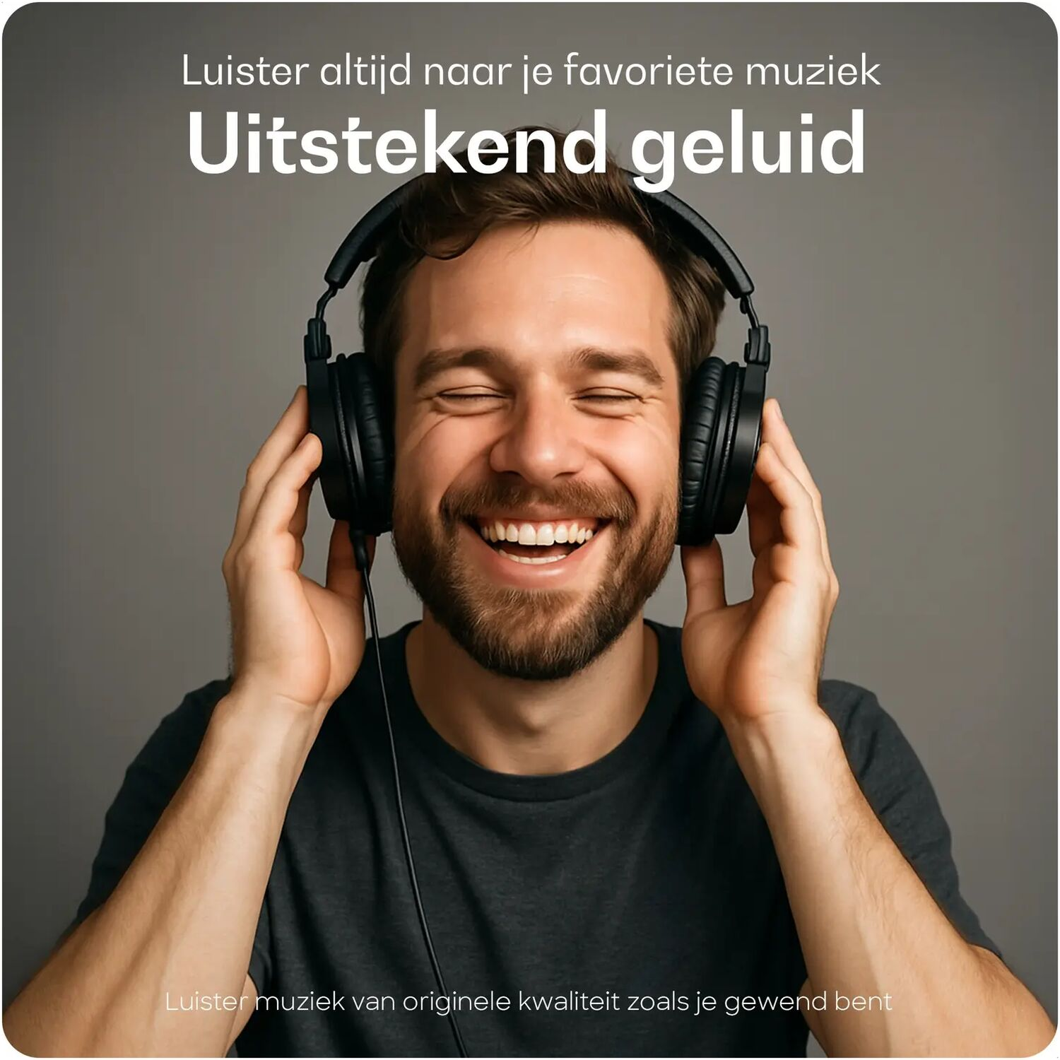 Man with headphones laughs, holding them.