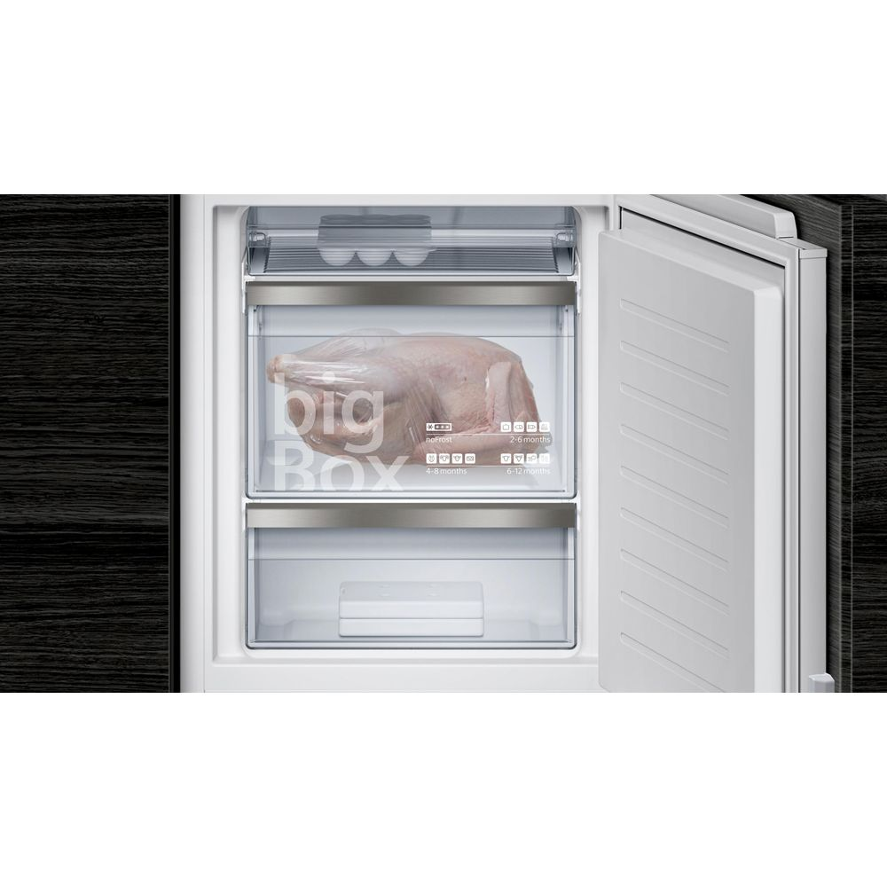 Ein großes rohes Hähnchen in einer Gefrierbox im Kühlschrank.