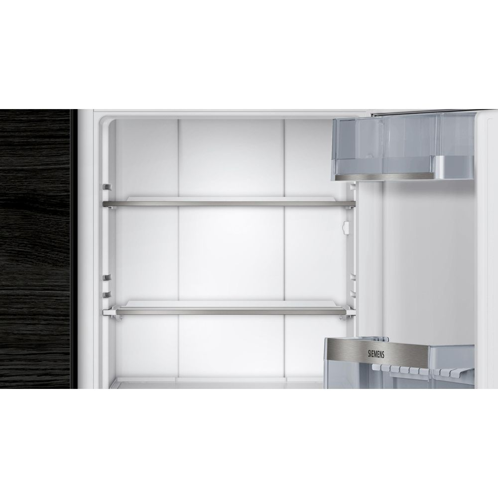 Leerer Kühlschrank mit drei Regalen und transparenten Behältern.