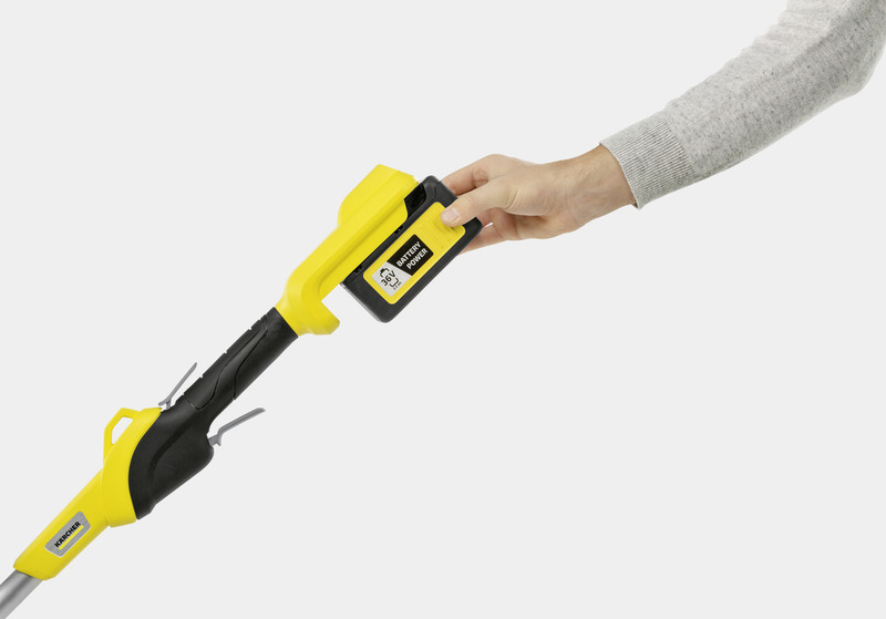 Eine Hand setzt einen gelben 36V Akku in ein Gartengerät ein.