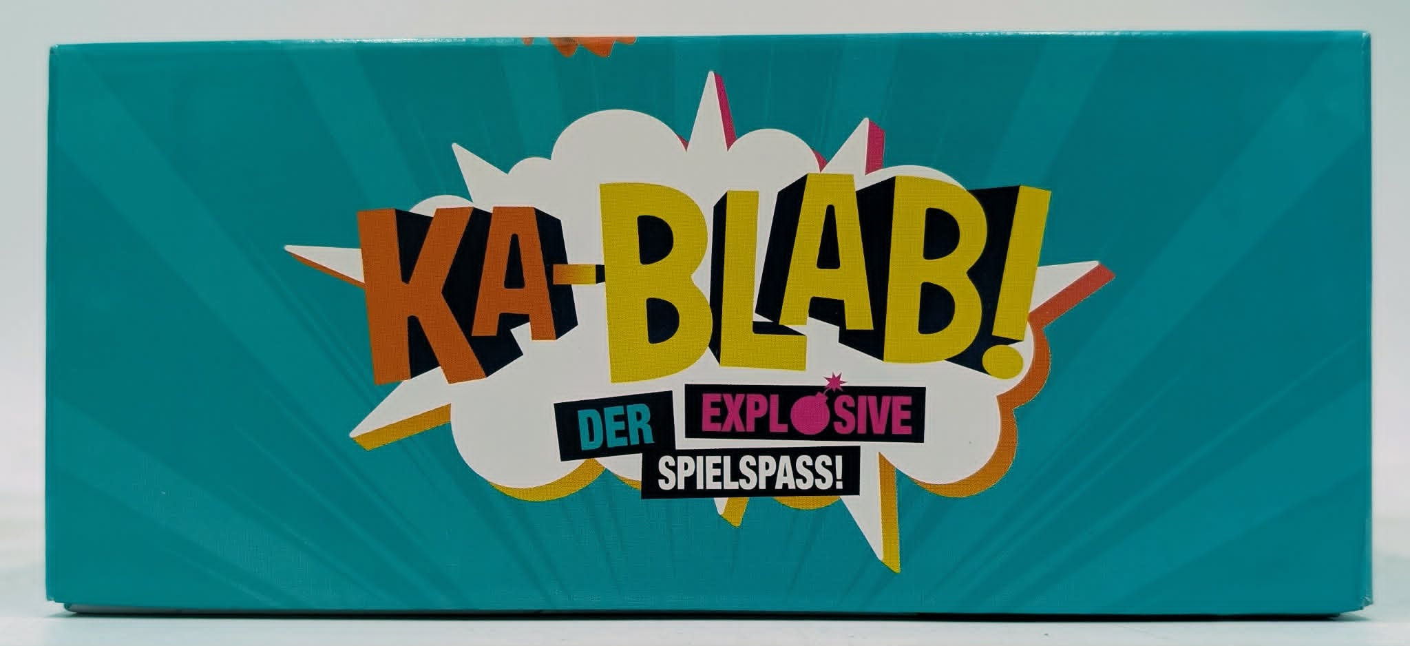 Türkiser Karton mit dem Aufdruck "KA-BLAB! DER EXPLOSIVE SPIELSPASS!"