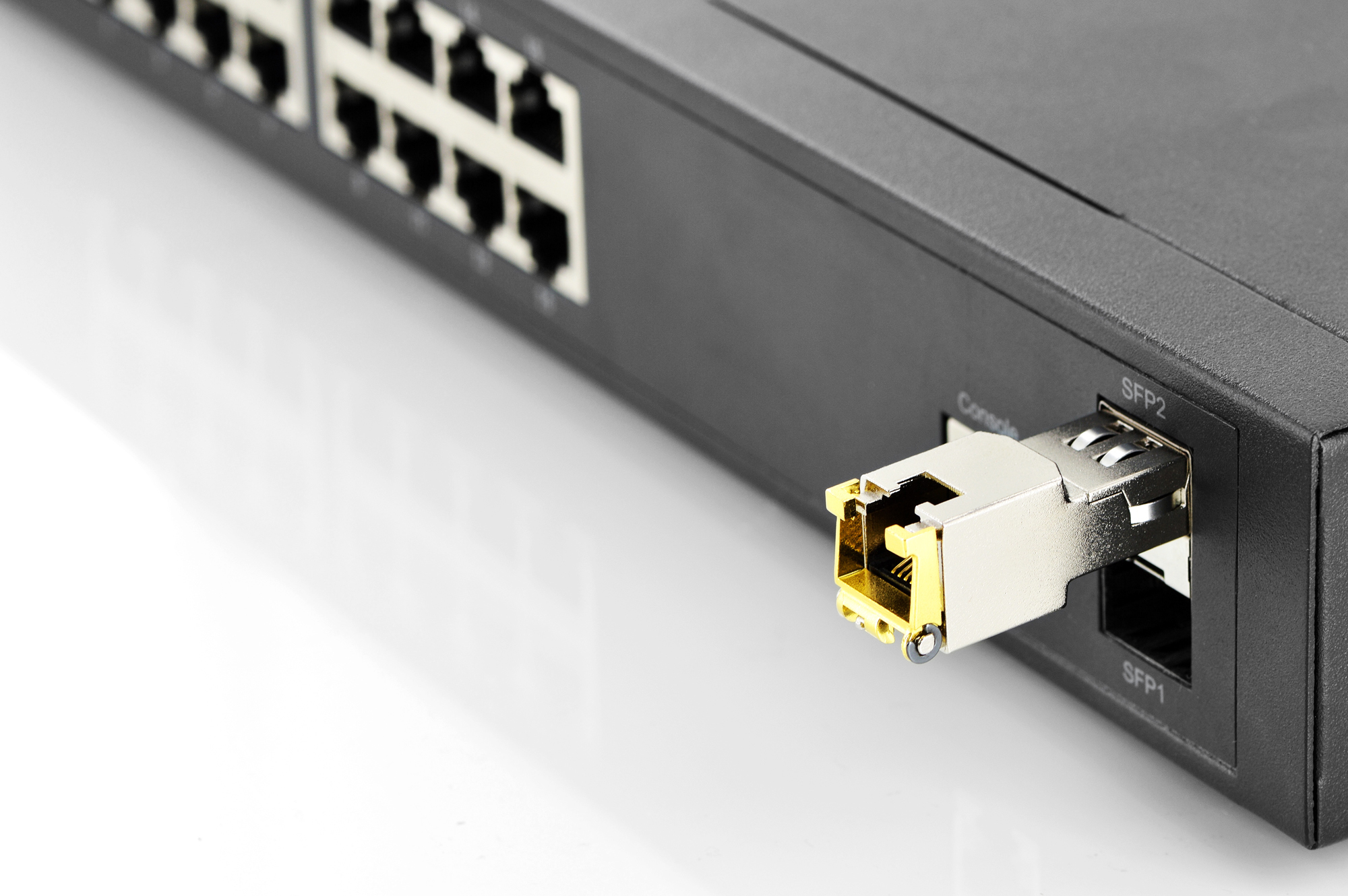 Primo piano di un dispositivo di rete con modulo SFP inserito e porte Ethernet.