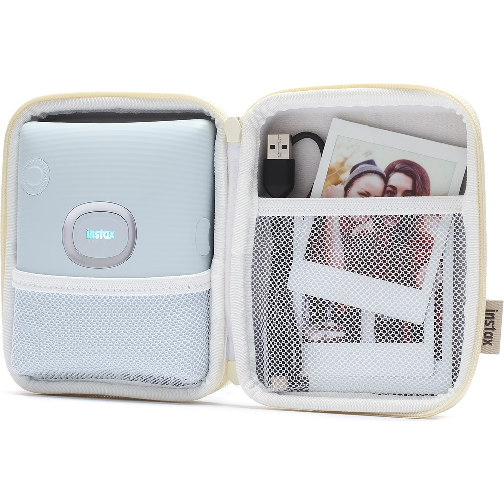 Açık mavi Instax kamera ve USB kablolu açık krem rengi çantada fotoğraflar.