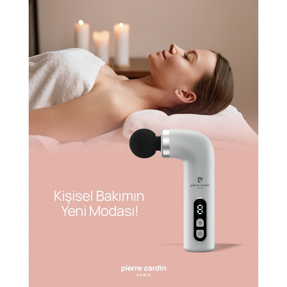 Bir kadın masaj yatağında rahat bir şekilde yatıyor, yanında masaj tabancası var.