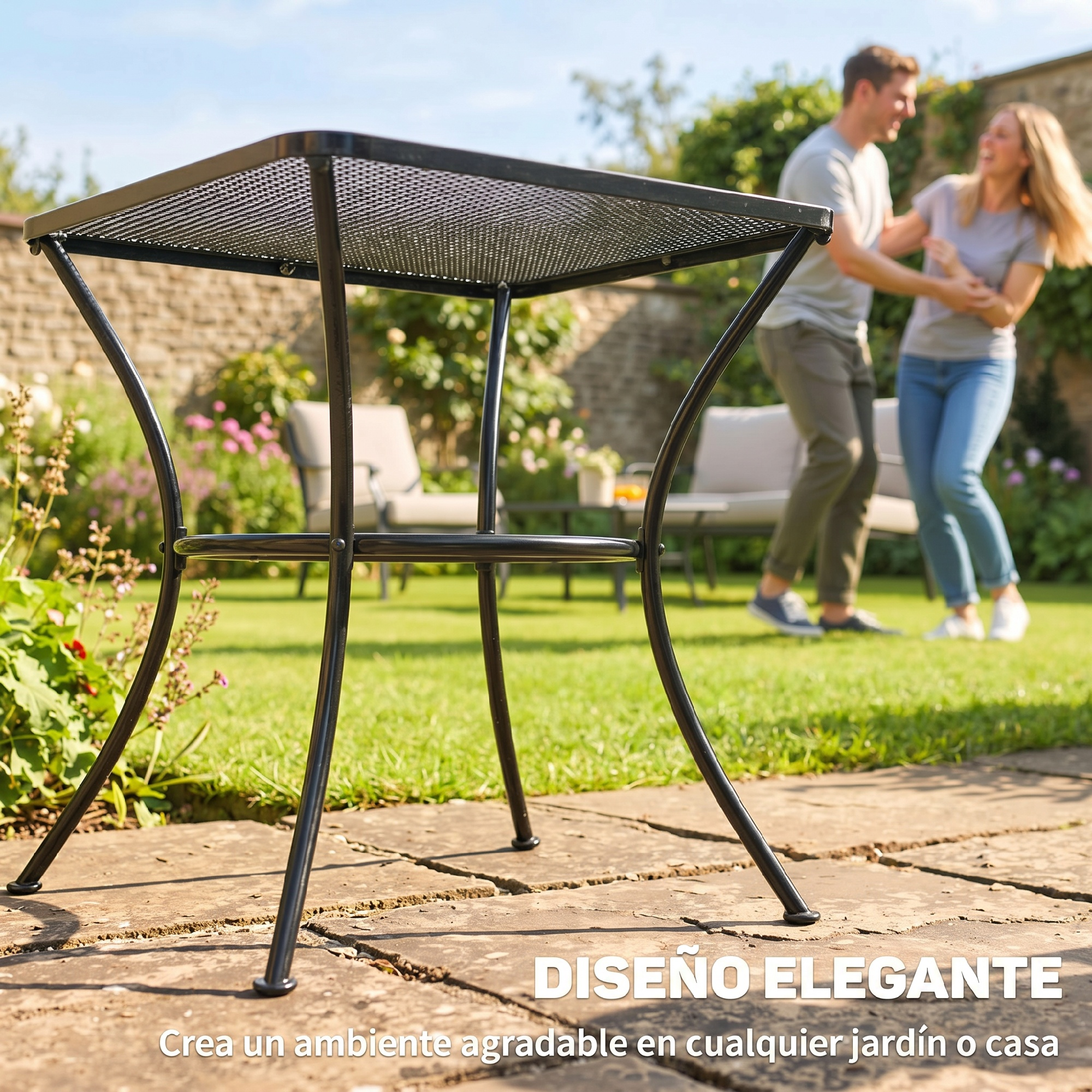 Una pareja baila en un jardín junto a una mesa negra de metal. Día soleado.