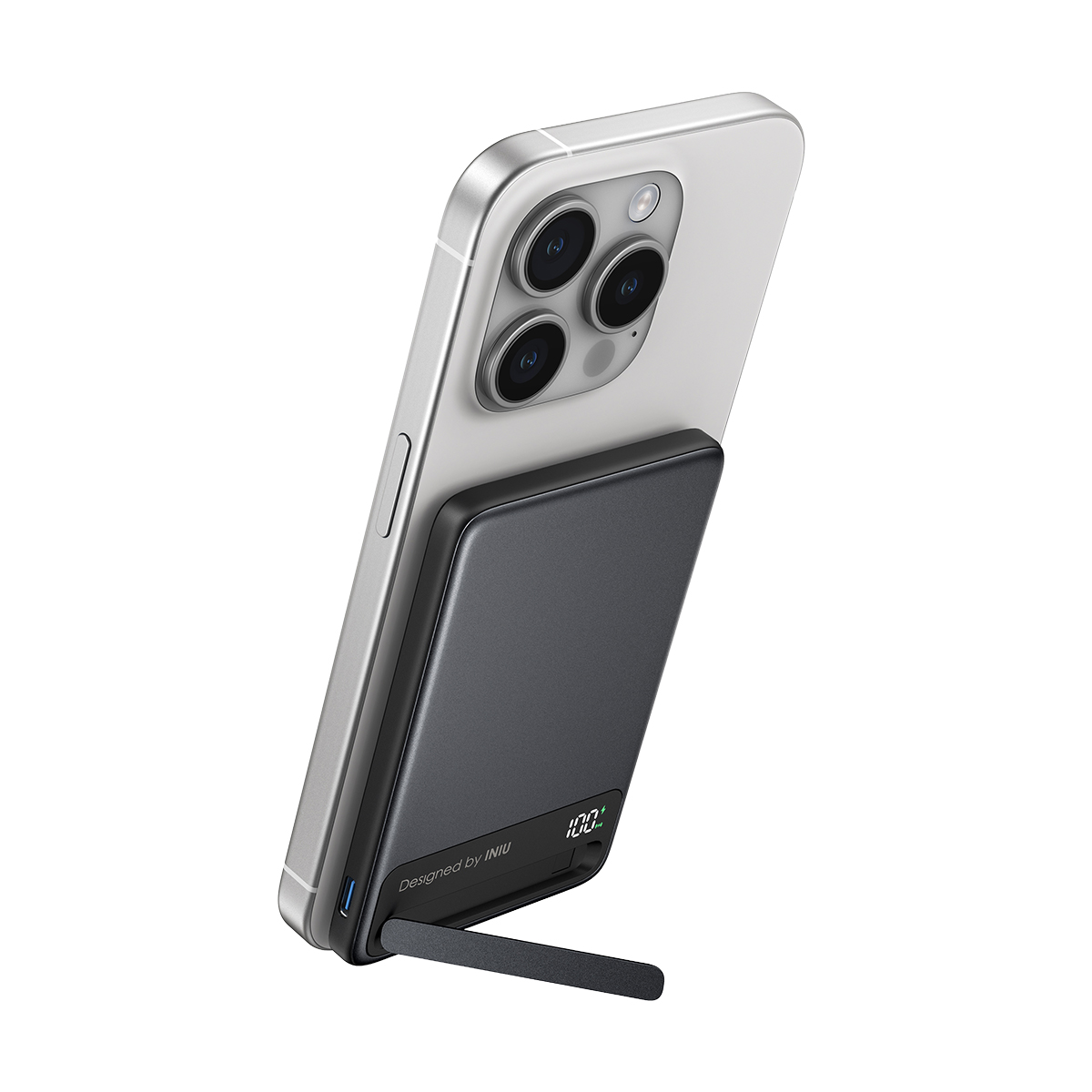 Batería externa gris con pantalla del 100%, unida magnéticamente a un smartphone plateado.