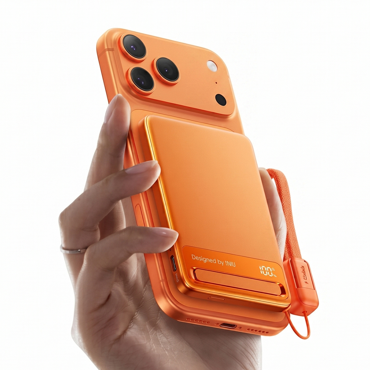 Mano sosteniendo un teléfono naranja con funda de batería externa. Lentes de cámara visibles.