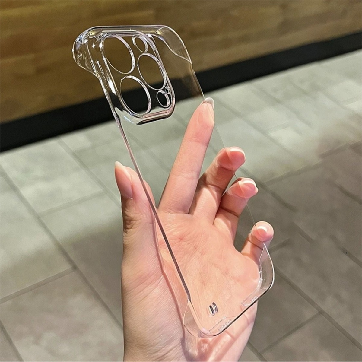 Eine durchsichtige Handyhülle mit Aussparungen für die Kamera, die von einer Hand gehalten wird.