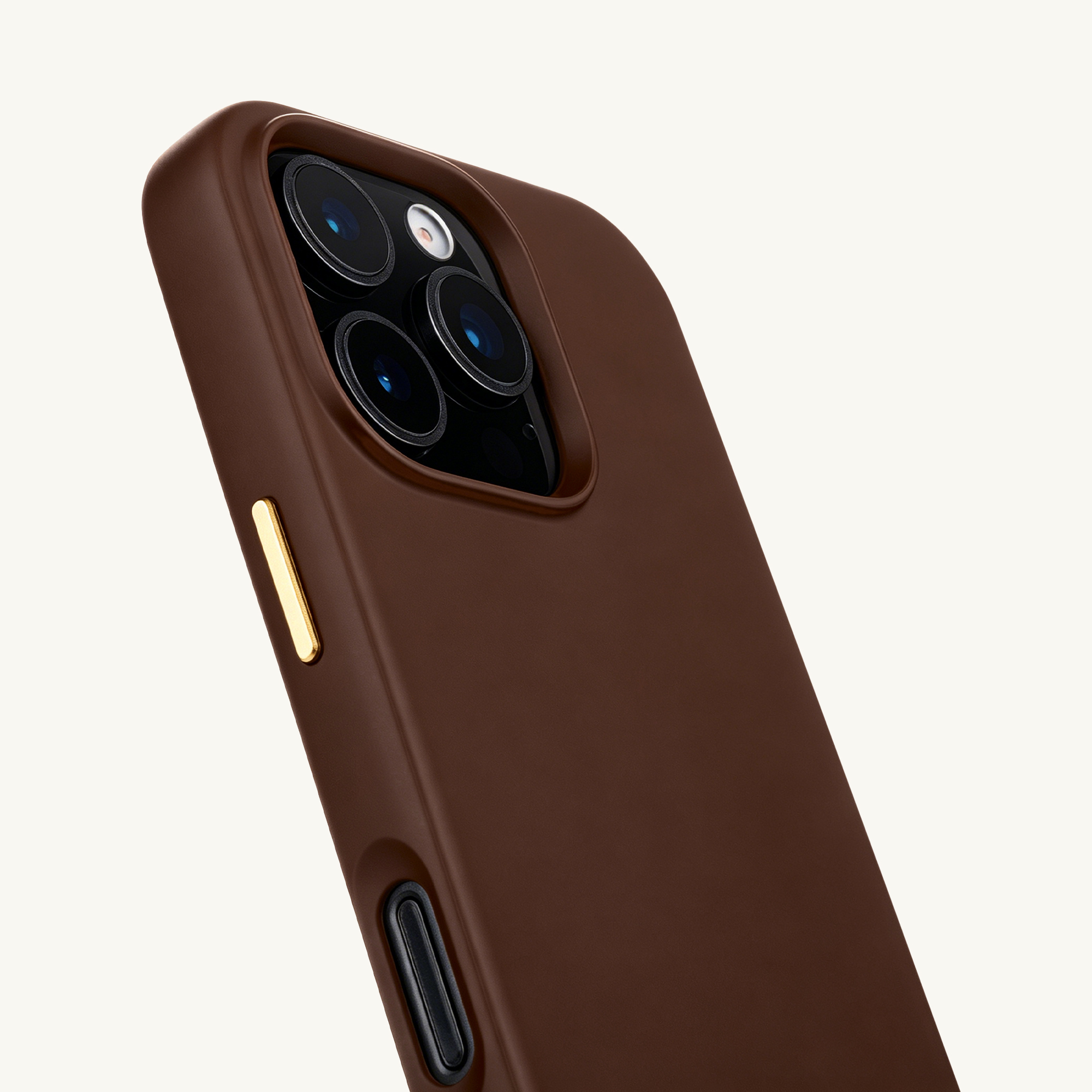 Funda de teléfono marrón con lentes de cámara y detalles dorados.