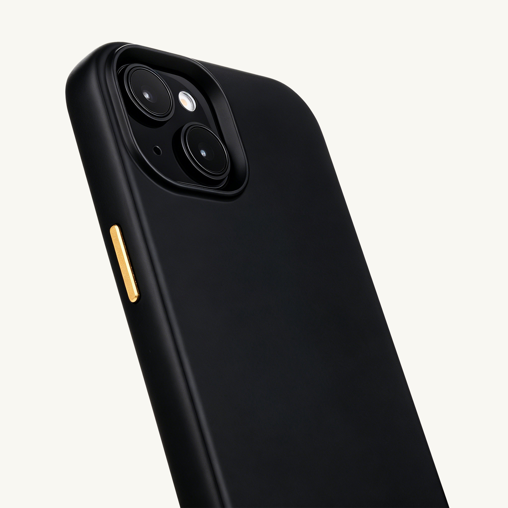 Black phone case with gold button and camera module on a light background.