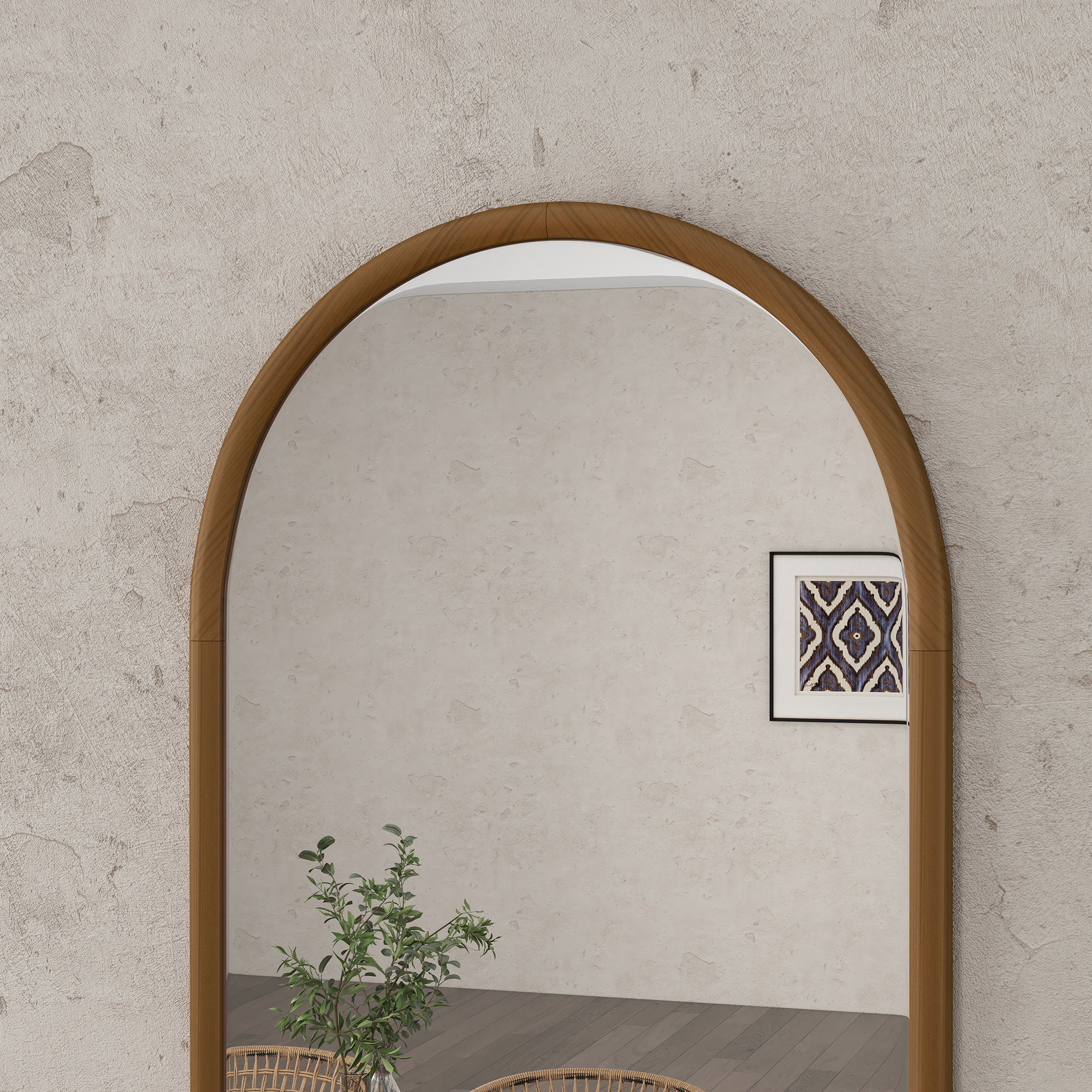 Un espejo con marco de madera frente a una pared texturizada, con una planta en una cesta al lado.