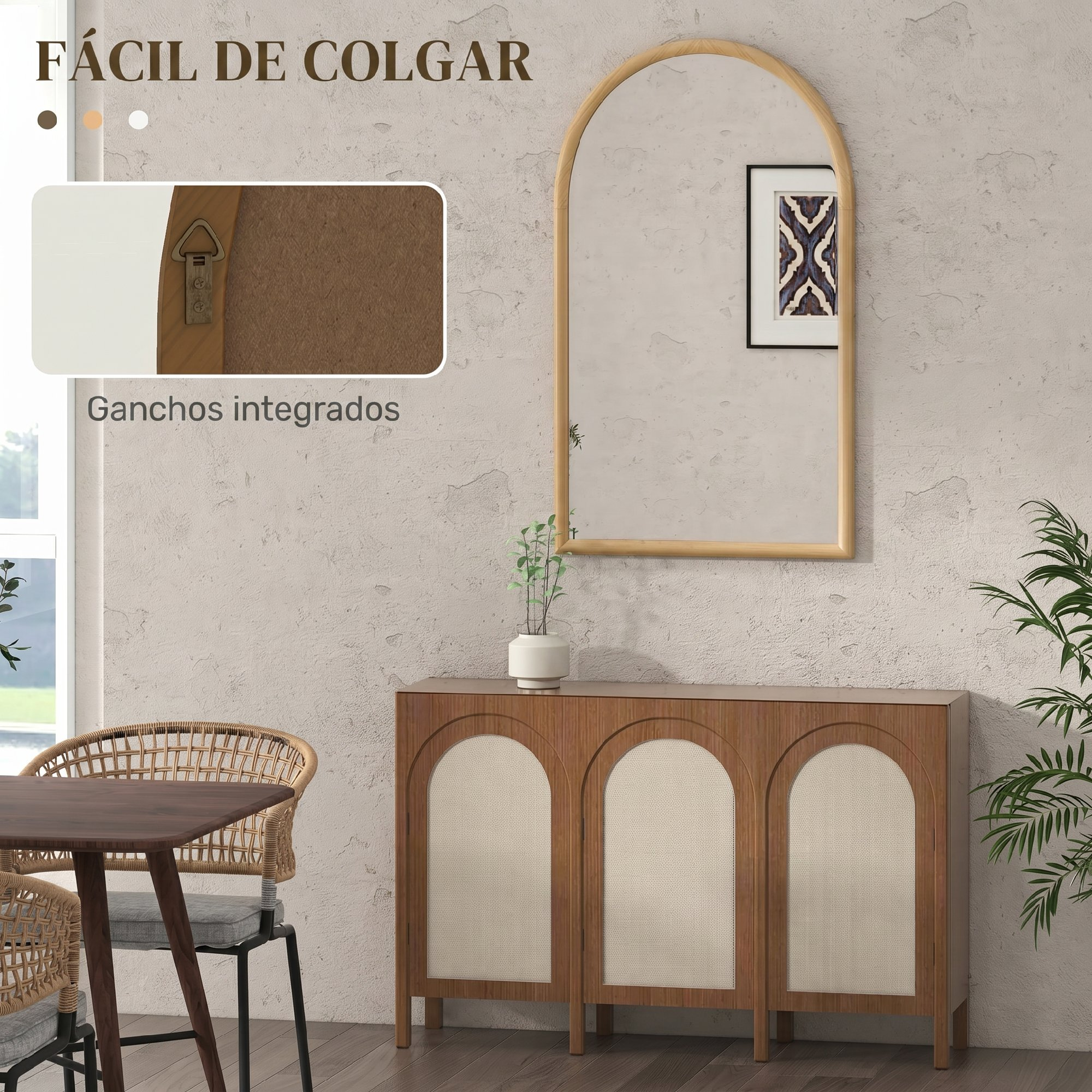 Un espejo sobre un mueble de madera con tres puertas arqueadas y una mesa con sillas de ratán.