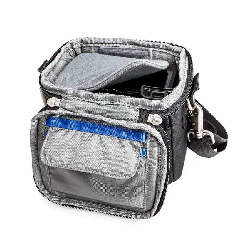 Una bolsa de cámara negra abierta con forro gris y un bolsillo frontal con ribete azul.