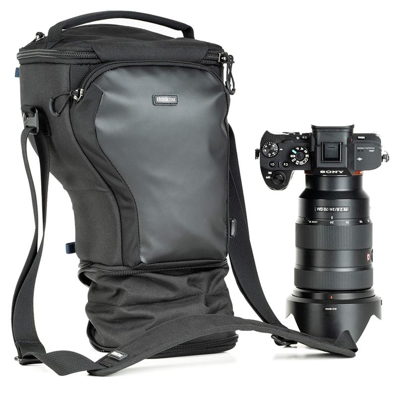 Bolso de cámara negro y cámara Sony con lente sobre fondo blanco.