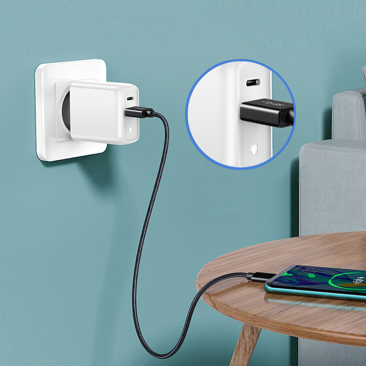 Ein wei'er Netzstecker l'ad ein Smartphone 'uber ein schwarzes Kabel.