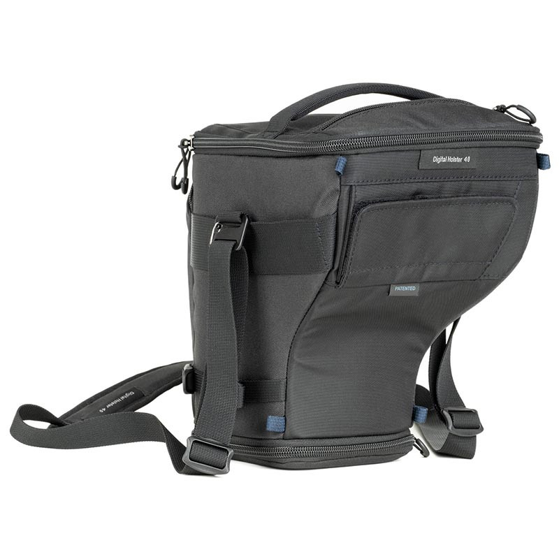 Bolso de cámara negro con asa y correas, sobre fondo blanco.