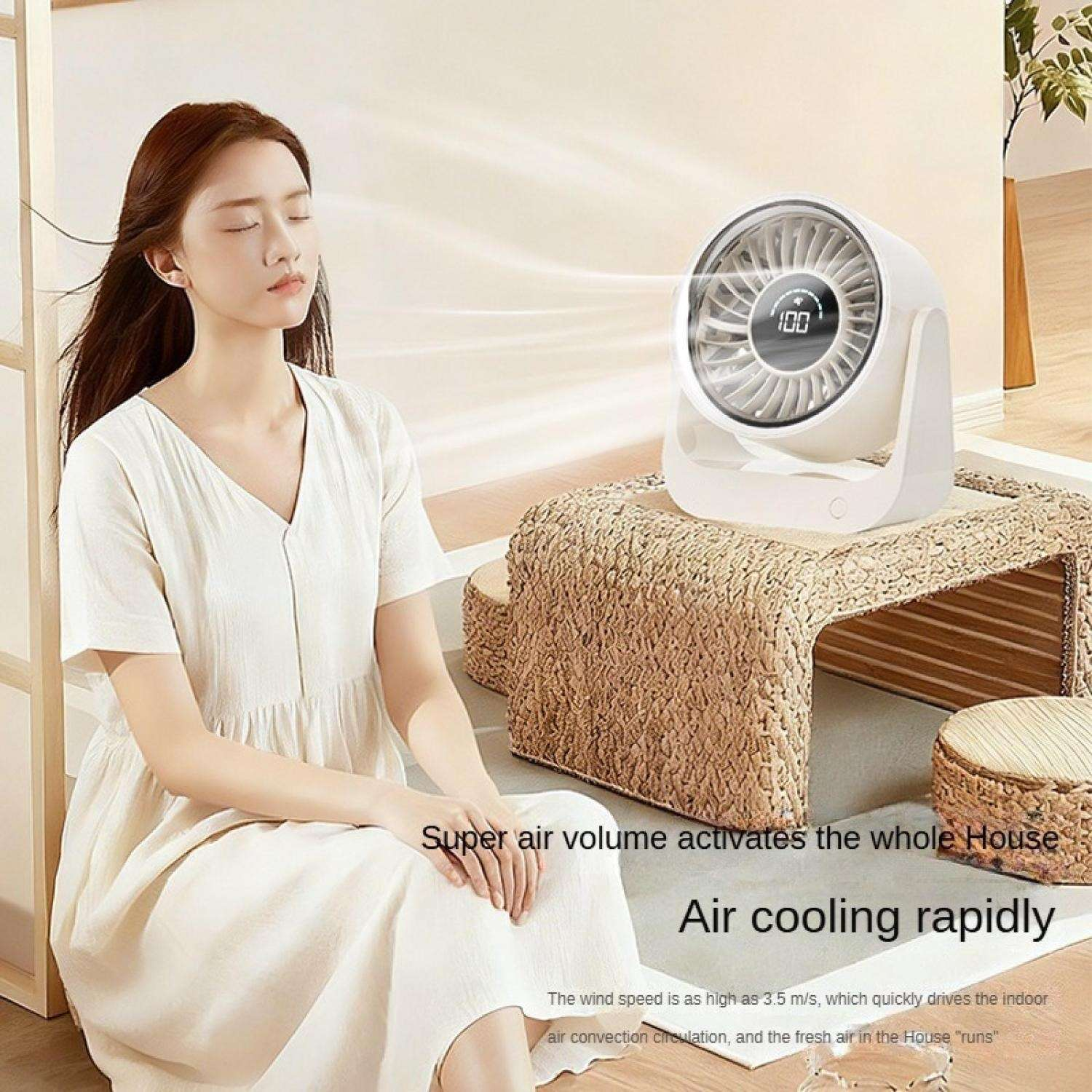 Eine Frau sitzt vor einem Ventilator, der Luft in die ganze Wohnung bläst.