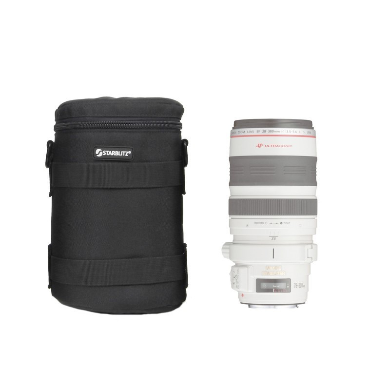 Bolsa negra para cámara junto a un lente Canon blanco con anillos rojos y grises.