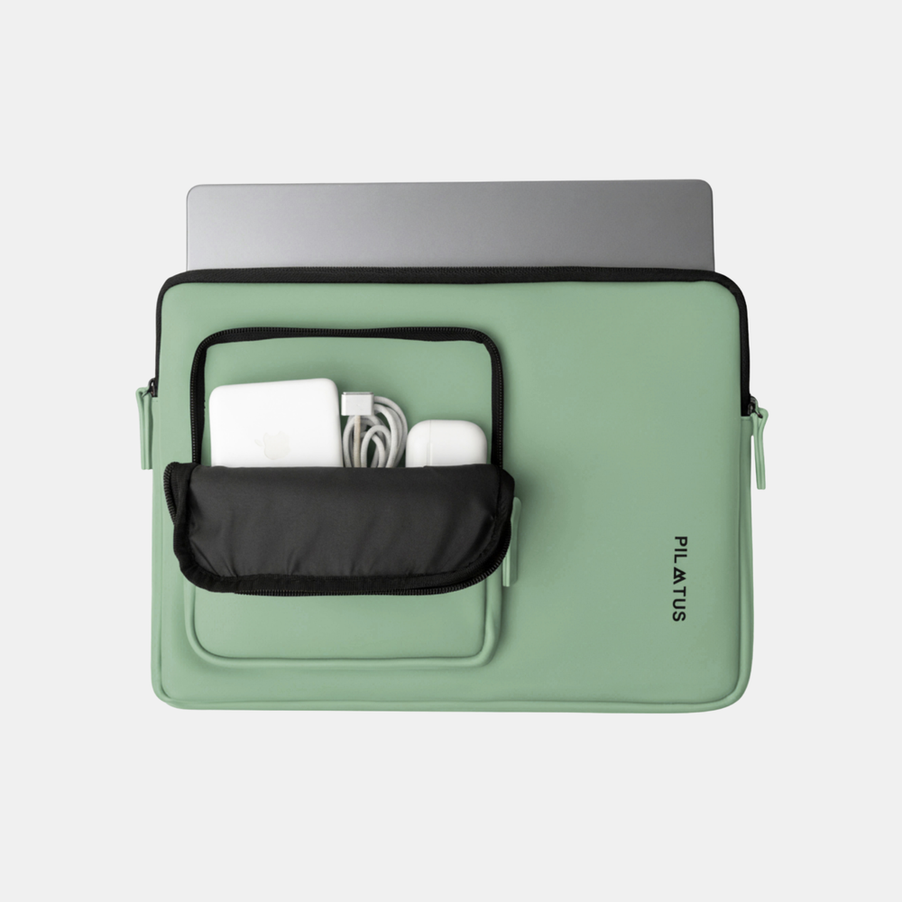 Custodia verde per laptop con laptop, caricabatterie e auricolari nella tasca frontale.