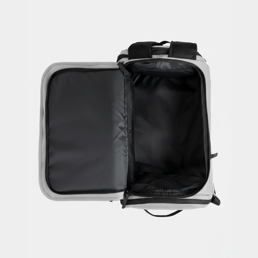 Borsa da viaggio grigia aperta con cinghie nere e interno nero su sfondo bianco.