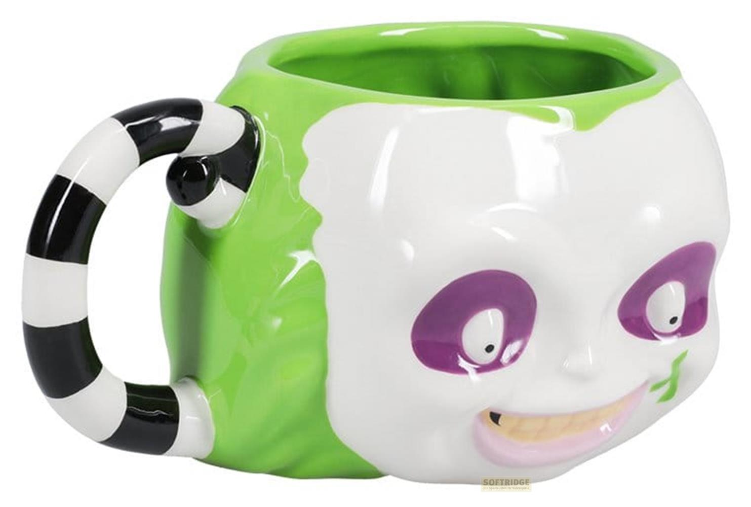Grüne Tasse mit weißem Gesicht, lila Augen und schwarz-weißer Henkel.