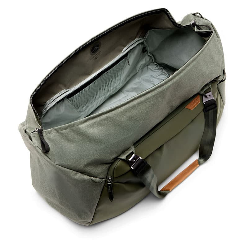 Grüne Reisetasche mit offenem Hauptfach, Netz- und Reißverschlusstaschen.