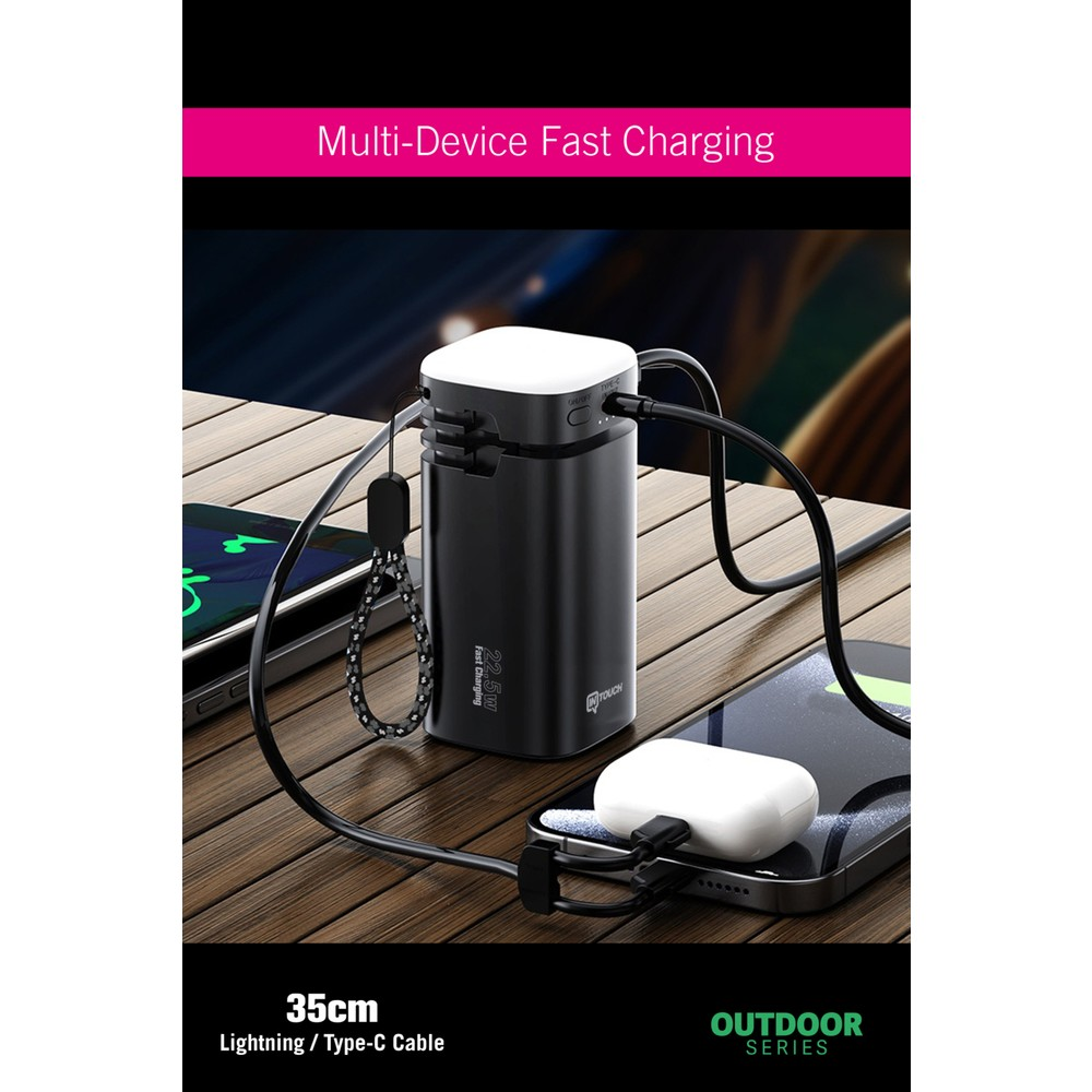 Siyah powerbank ahşap masada telefonları ve kulaklıkları şarj ediyor.