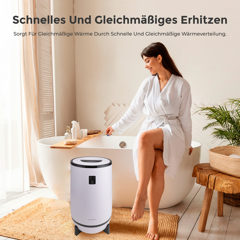 Frau im Bademantel sitzt neben einem Heizgerät im Badezimmer.