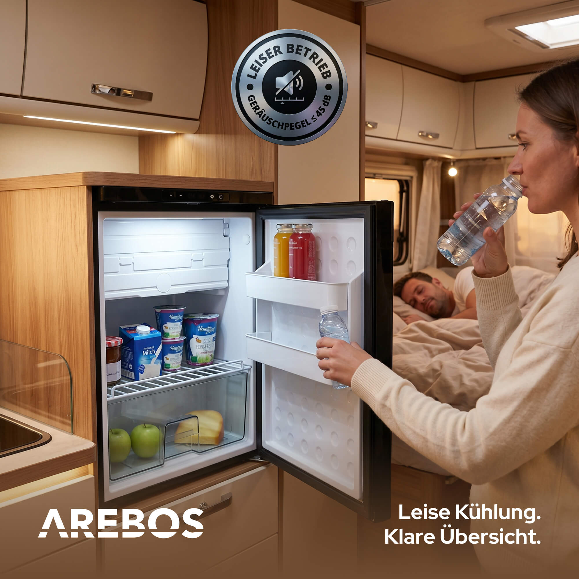 Ein offener Kühlschrank mit Lebensmitteln, daneben trinkt eine Frau Wasser.