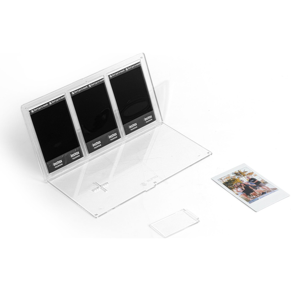 Yanında bir fotoğraf bulunan, üç boş Instax film içeren şeffaf bir kap.