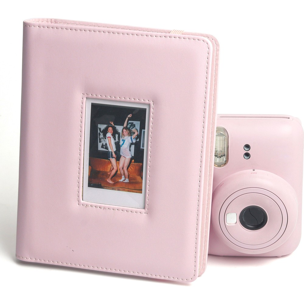 İki kadının fotoğrafının ve yanında pembe bir anında fotoğraf makinesinin olduğu pembe albüm.
