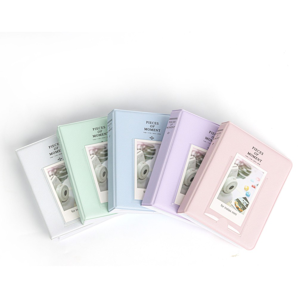 Beyaz arka plan üzerinde beş pastel renkli fotoğraf albümü. Her albümde bir kamera fotoğrafı var.