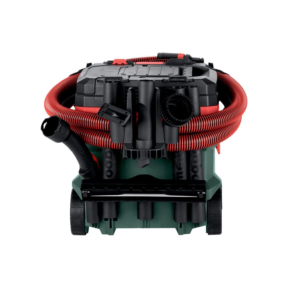 Un aspirapolvere verde e nero con tubo rosso e accessori.
